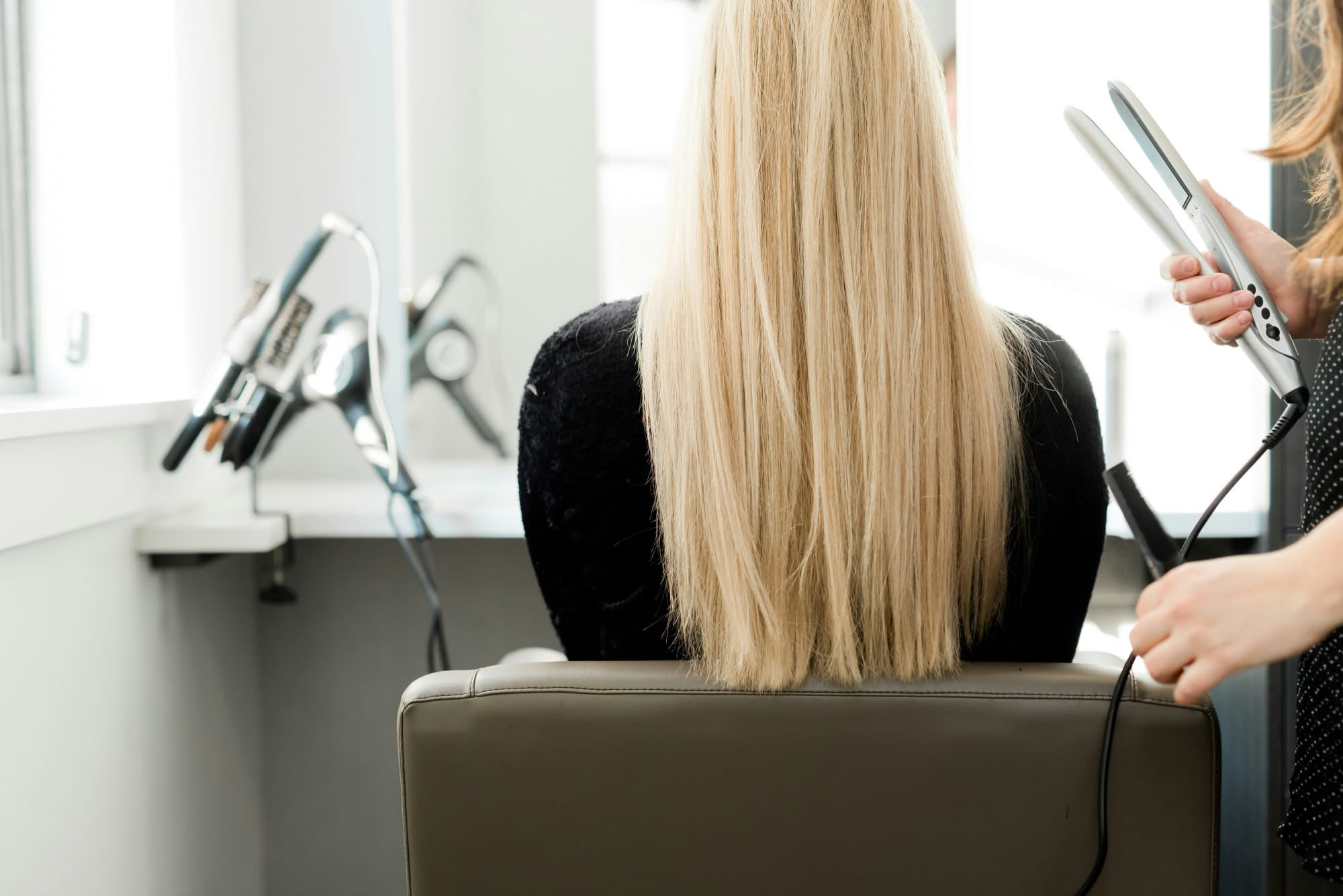 Donna con capelli lisci biondi appiattiti dopo esposizione al caldo estivo, confronto visivo tra capelli con volume e senza